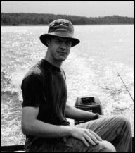 Joel in a green metal boat, heading home